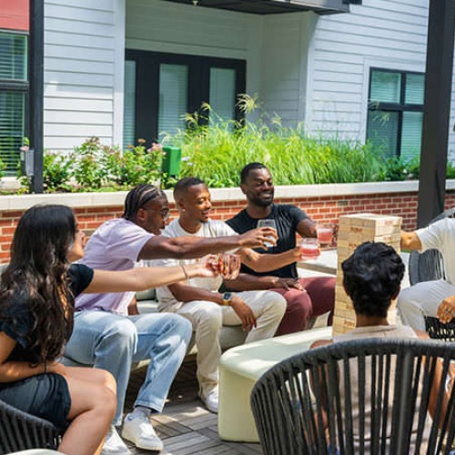 residents play Jenga on outdoor patio